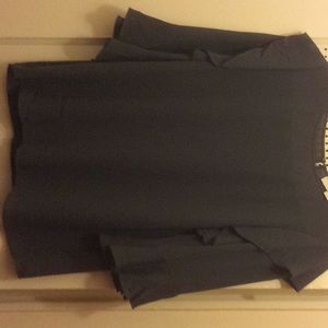 Gray/lavender blouse with ruffle on the/bottom.